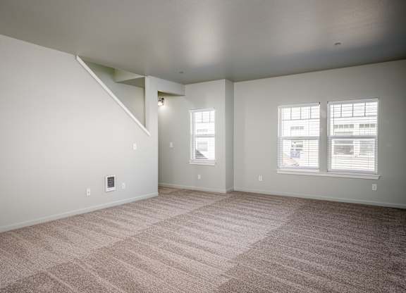 A room with a carpeted floor and a window.