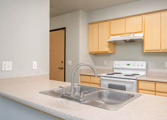 A kitchen with a stove, oven, and sink.