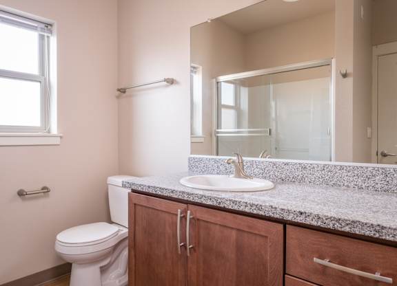 an empty bathroom with a toilet sink and mirror