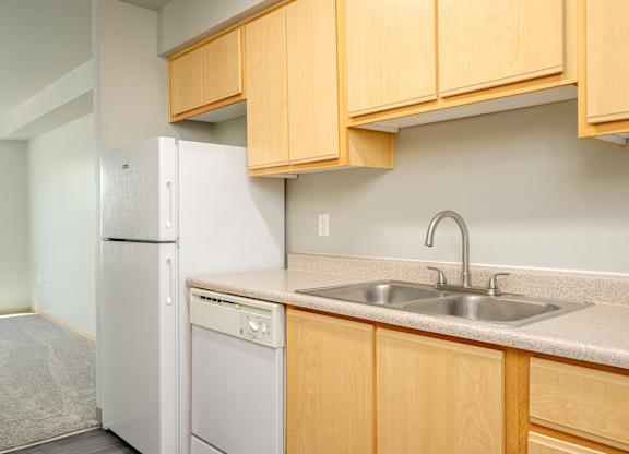 A kitchen with a white refrigerator and a white dishwasher.