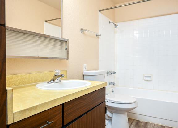 A bathroom with a sink, toilet, and bathtub.