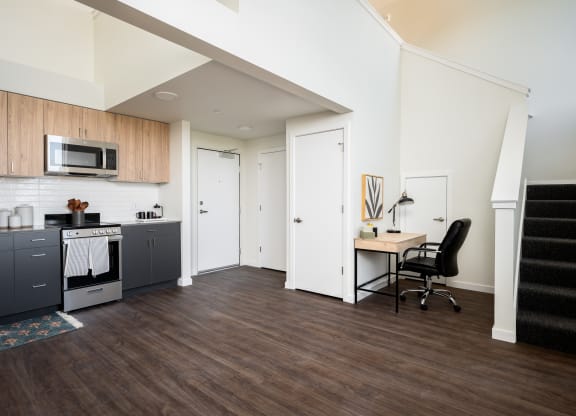 View of studio living room, kitchen and stairway to loft