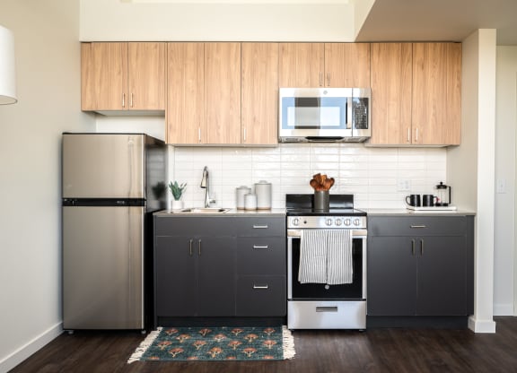 a kitchen with stainless steel appliances and two-tone wooden cabinets
