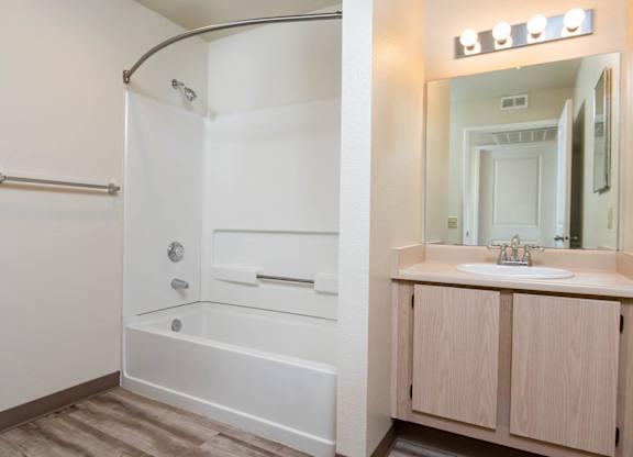 A white bathroom with a walk-in shower and a sink.