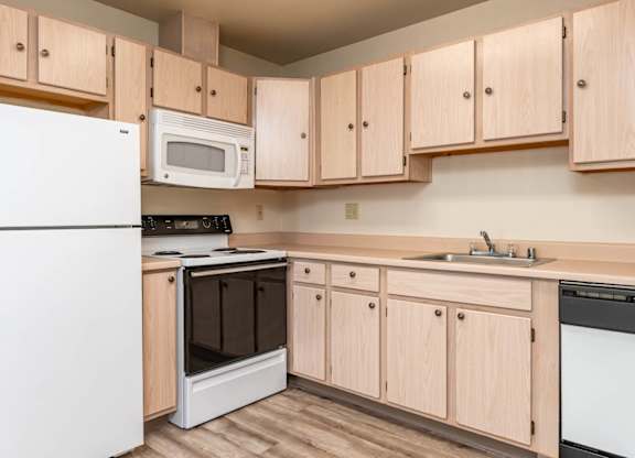 A kitchen with wooden cabinets and white appliances.