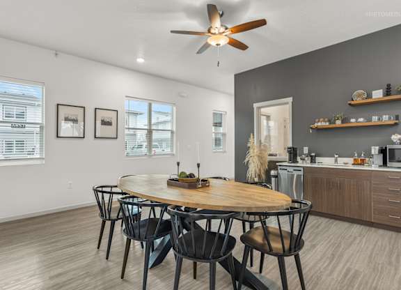 A modern dining room with a round wooden table and chairs.