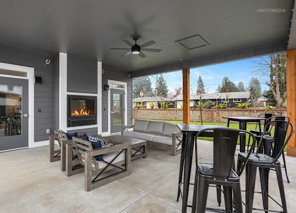 A patio with a fireplace and seating area.