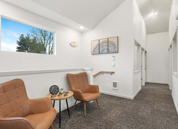 A living room with two chairs and a table.