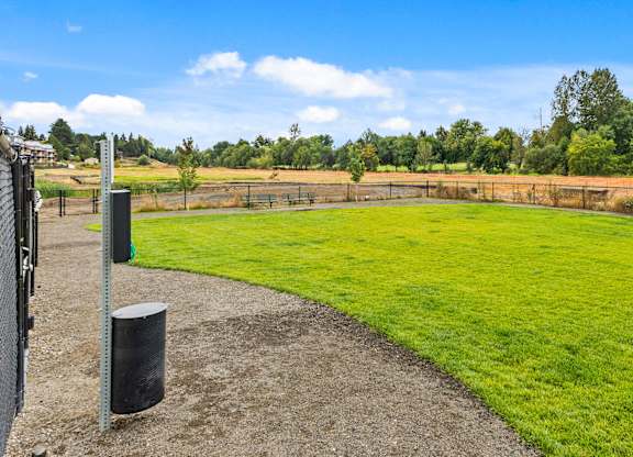 A grassy field with a fence and a signpost.