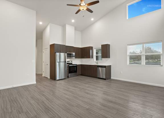 A modern kitchen with a refrigerator, microwave, and oven.
