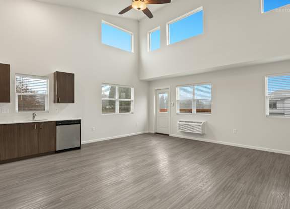 A spacious room with a ceiling fan and large windows.