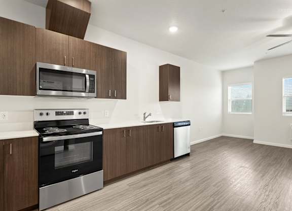 A modern kitchen with wooden cabinets and stainless steel appliances.