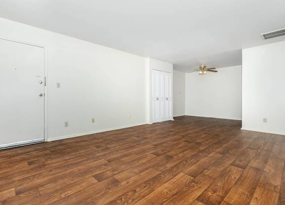 A room with wooden flooring and white walls.