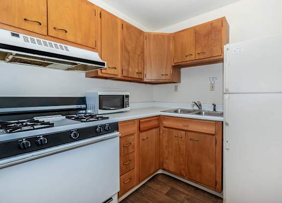 A kitchen with wooden cabinets and a white refrigerator.