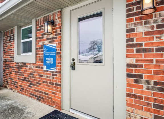 A white door with a sign on the wall that says