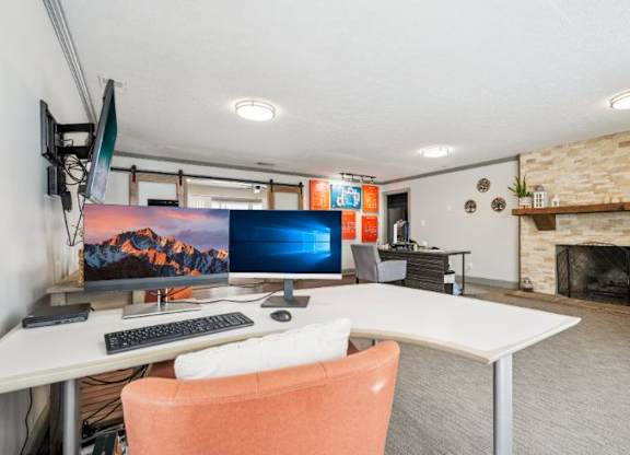 A room with a desk, chair, and a fireplace.