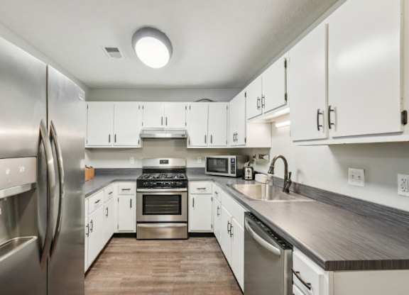 A modern kitchen with stainless steel appliances and white cabinets.