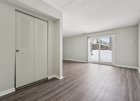 A room with a sliding door and wood flooring.