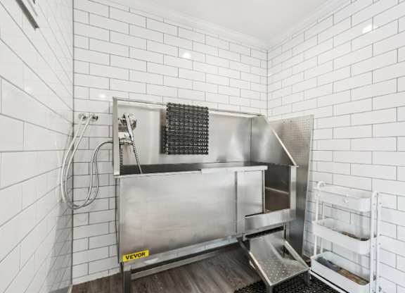 A stainless steel kitchen sink with a drainboard and a dish rack.