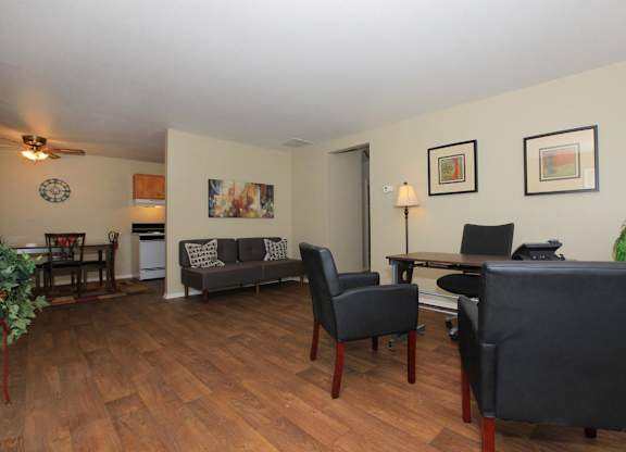 A living room with a grey couch and a wooden floor.