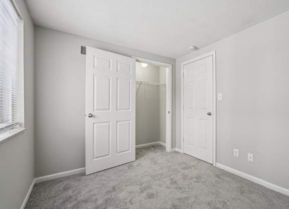 A room with two white doors and a carpeted floor.