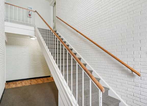 A staircase with white railings and wooden handrails.