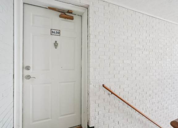 A white door with a number plate on it.