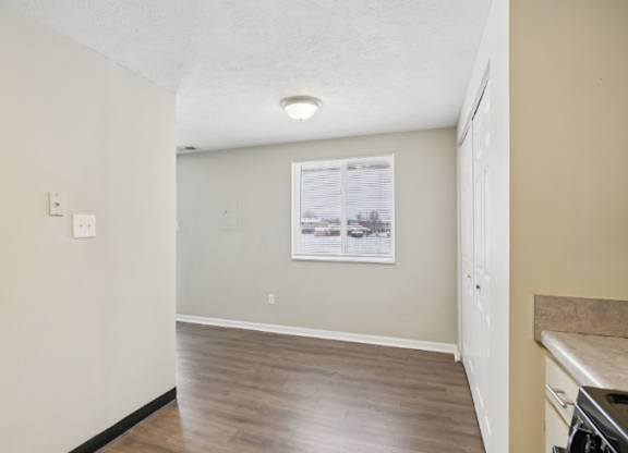 A room with a window and a wooden floor.