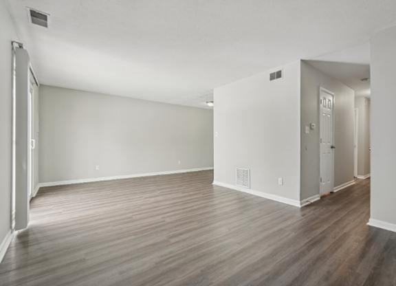A room with wooden flooring and white walls.