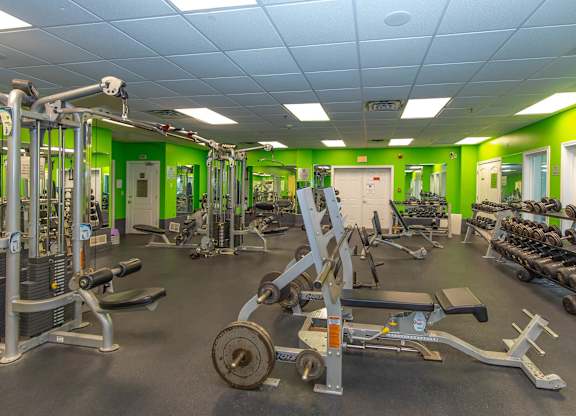 A gym with a variety of equipment including weights and weight machines.