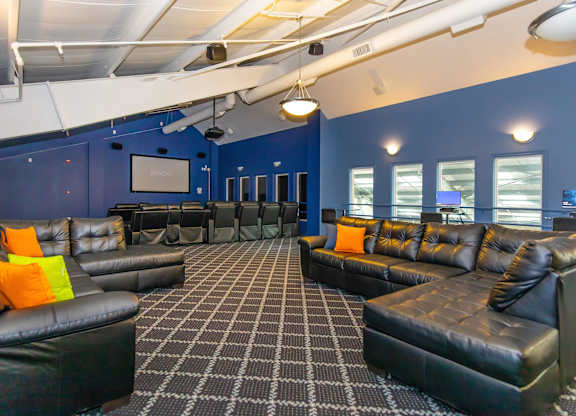 A room with black leather couches and a checkered floor.