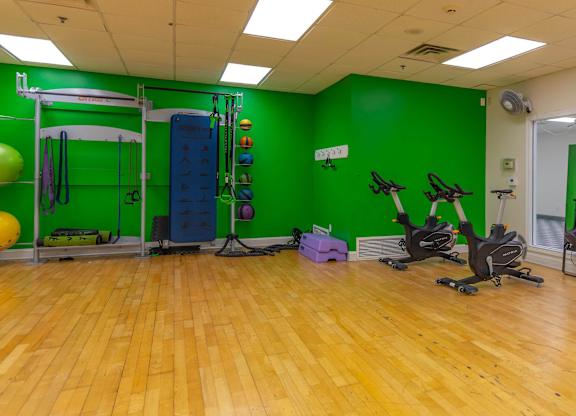A gym with a green wall and wooden floor.