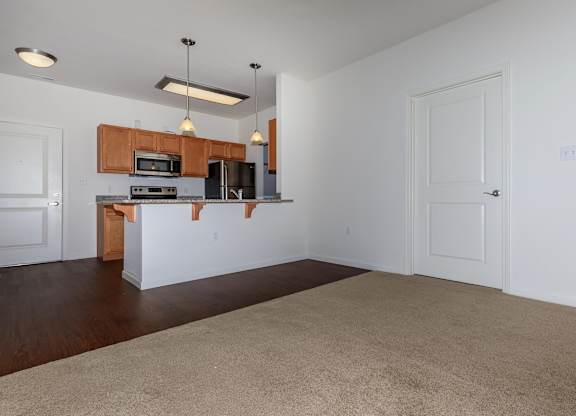A kitchen with white walls and wooden cabinets.