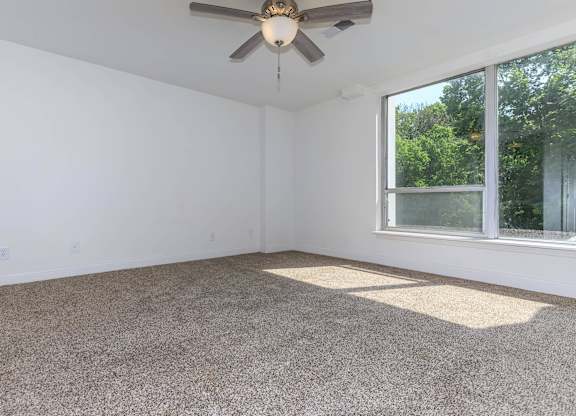 A room with a ceiling fan and a window.