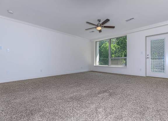 A room with a ceiling fan and carpeted floor.