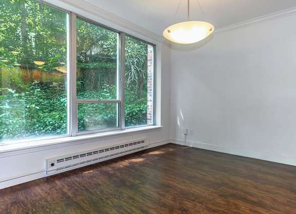 A room with a window and a light hanging from the ceiling.