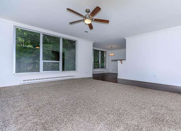 A room with a ceiling fan and carpeted floor.