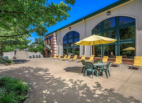 A sunny day at a cafe with tables and chairs under umbrellas.