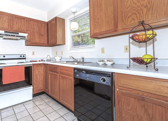 A kitchen with wooden cabinets and a white oven.