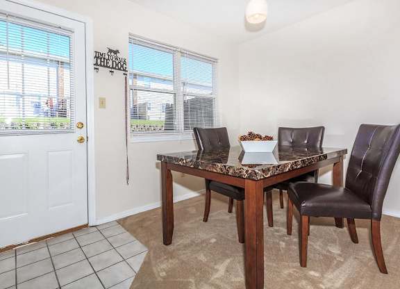 A dining room with a table and chairs.