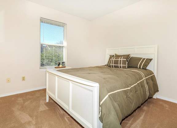 A bedroom with a large bed and a window.