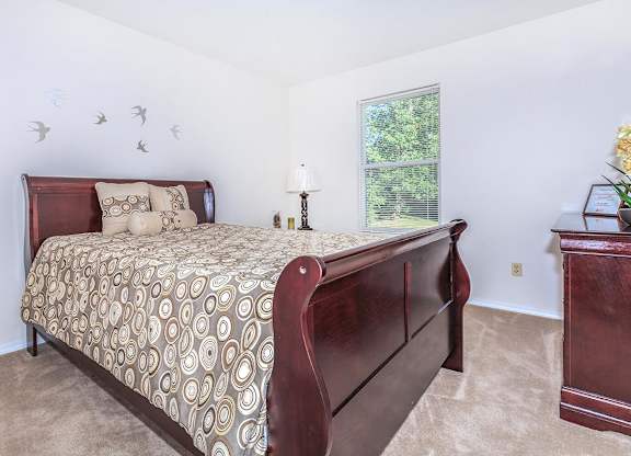 A bedroom with a large bed and a window.
