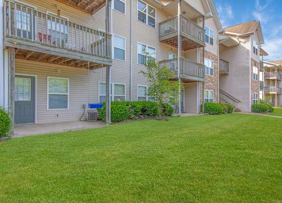 Apartment complex with green grass in front.