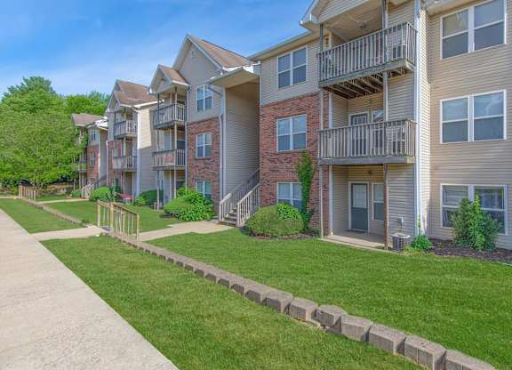 Apartment complex with a grassy area in front.