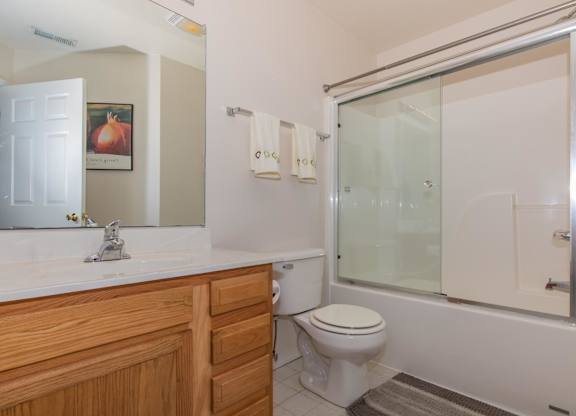 A bathroom with a toilet, sink, and shower.