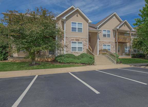 Apartment building with a parking lot in front.