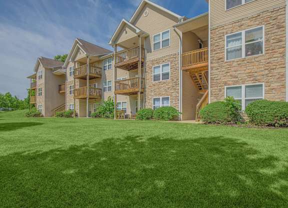 A large grassy area in front of apartment buildings.