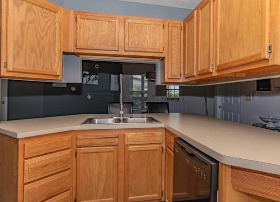 A kitchen with wooden cabinets and a stainless steel sink.