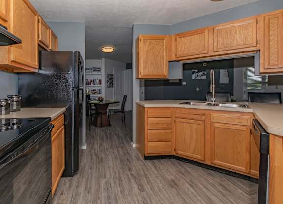 A kitchen with wooden cabinets and black appliances.