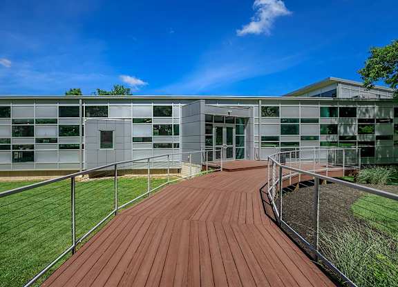 A modern building with a wooden walkway leading to the entrance.